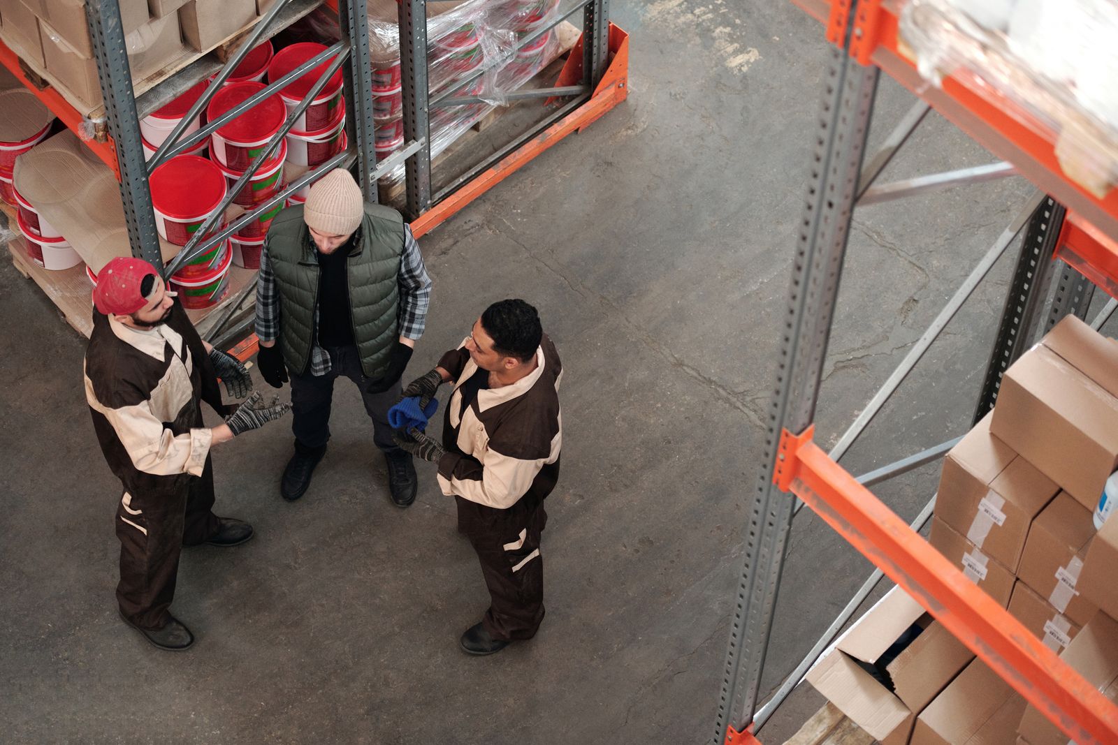 Warehouse workers talking in practical workwear and gloves